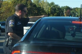 West Hartford Police Officer Mike Coyne speaks with a cellphone violator who is about to get a ticket. Photo credit: Ronni Newton