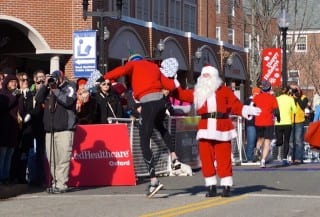 One runner clicked his heels for joy as he high-fived Santa at the finish line. Annual Blue Back Mitten Run, West Hartford, Dec. 7, 2014. Photo credit: Ronni Newton