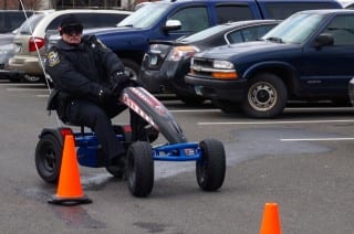 West Hartford Police Officer Brian Gallagher tests out the go-cart while wearing intoxication simulation goggles. Photo credit: Ronni Newton