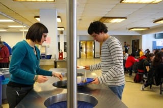 Hall science teacher Kathleen Coghill, faculty advisor to the Environmental Club, instructs student Gregory Donovan on sorting his waste. Photo credit: Ronni Newton