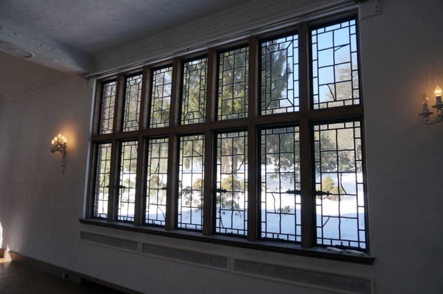 Casement windows line three walls of the living room. 2015 Junior League of Hartford Decorator Show House. Photo credit: Ronni Newton