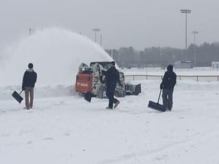 From left: Hall baseball players Brendan Horan, Ben Kriedel, and Collin Kuzia work on the snow removal with dad Jon Fitzsimond who brought and operated the Bobcat. Courtesy photo