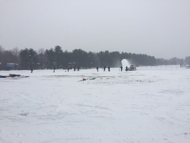 Parents, coaches, and players work to get the snow off the Hall varsity baseball field. Courtesy photo
