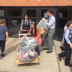 Smith STEM Principal Juan Melian and students cart some of the 2,200-plus pairs of donated shoes to a truck to be shipped for donation to underdeveloped countries. Submitted photo