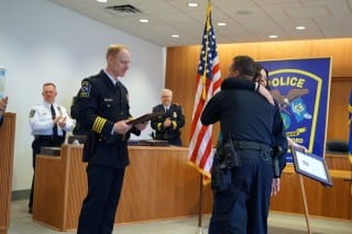Susan Callison, who received a Citizen Award from the WHPD, gets a hug from Officer Jeremy Allen who also received a Life Saving Award for assisting a West Hartford teen who collapsed on the KO track in June 2014. Chief Tracey Gove is at left. Photo credit: Ronni Newton