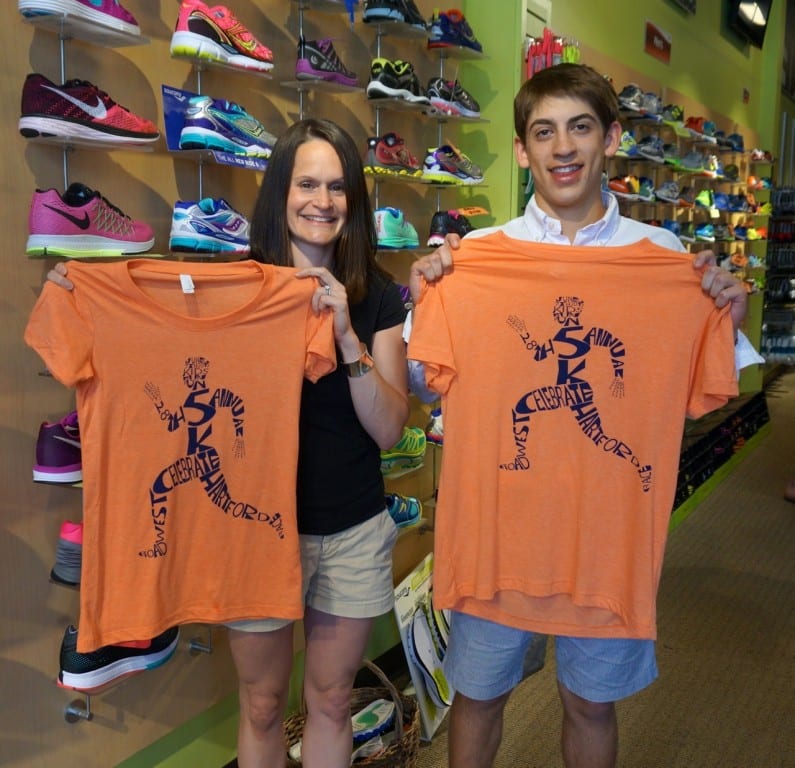 Marisa Jones, who has won the women's divisin of the Celebrate West Hartford Road Race a dozen times, poses with t-shirt design contest winner Andrew Hollerbach. Photo credit: Ronni Newton