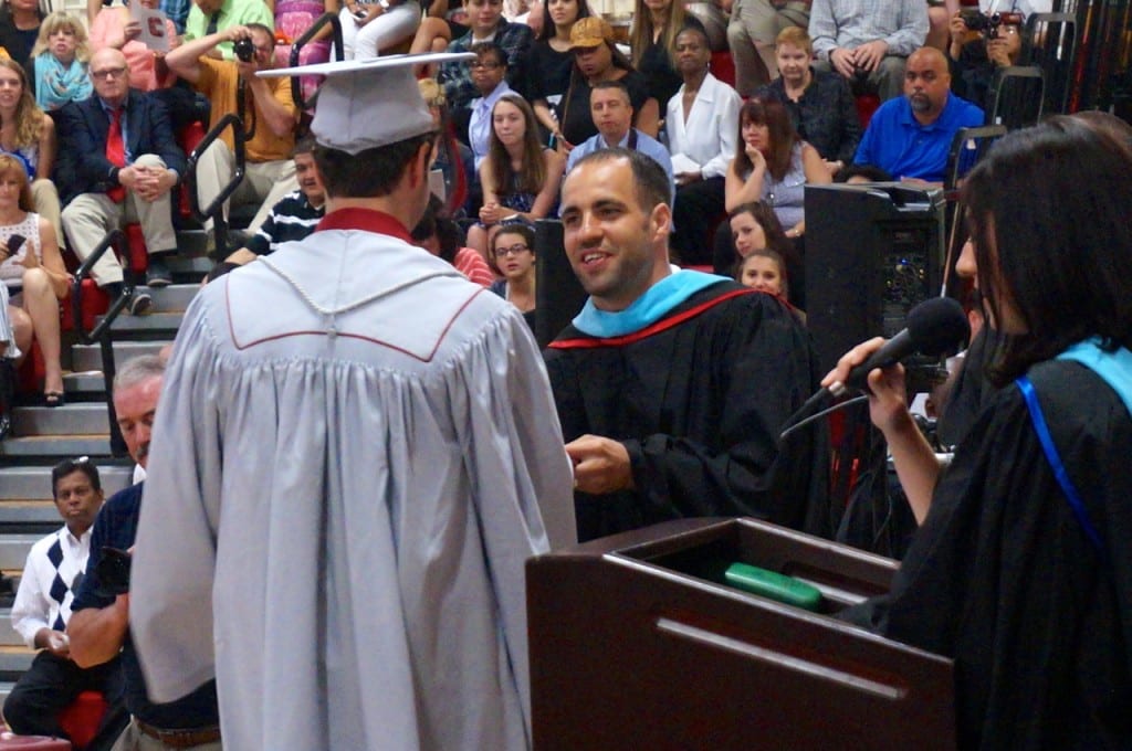 Conard Principal Julio Duarte hands out the first diploma to Travis Abrahamson. Conard High School graduation. June 15, 2015. Photo credit: Ronni Newton