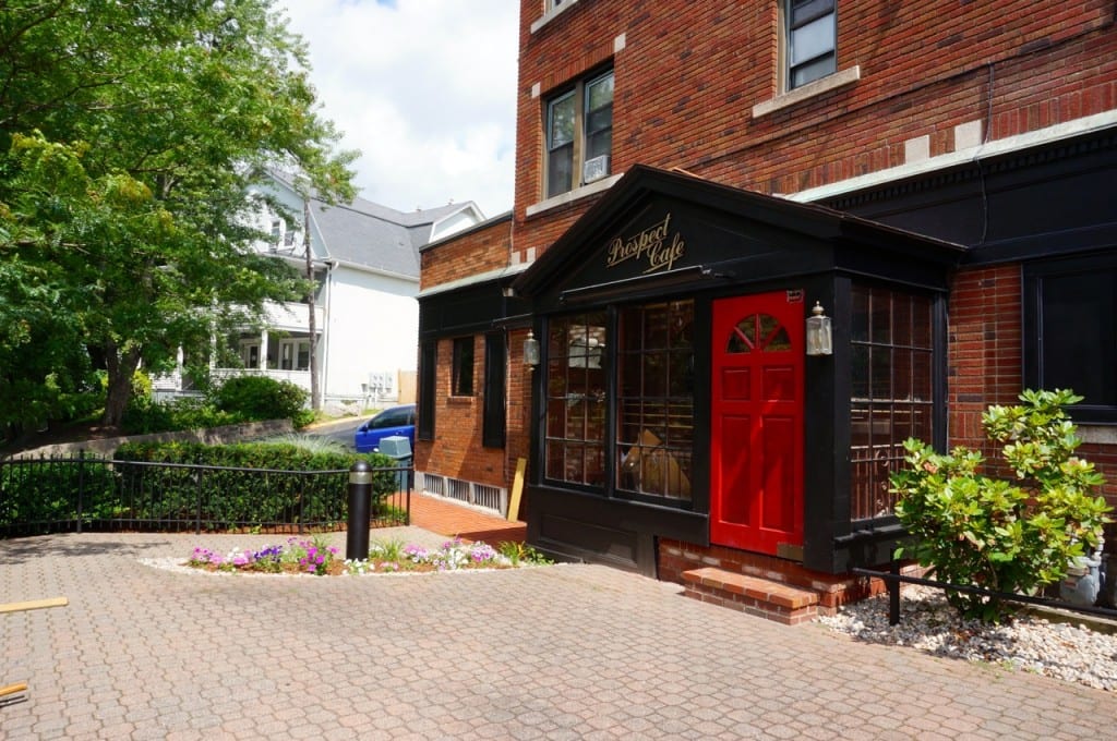 The exterior of the Prospect Café has fresh-painted black trim and glossy red doors. Photo credit: Ronni Newton