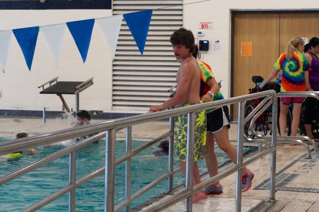 A volunteer at the Ivan Lendl Adaptive Sports Camp guides a camper into the accessible pool at the University of Saint Joseph in West Hartford. Photo credit: Ronni Newton