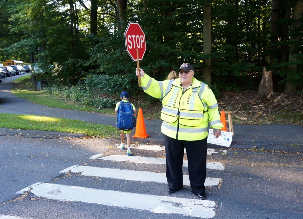 The crossing guard in front of Braeburn Elementary School greets everyone with a friendly welcome as she helps them safely cross Braeburn Road. Photo credit: Ronni Newton