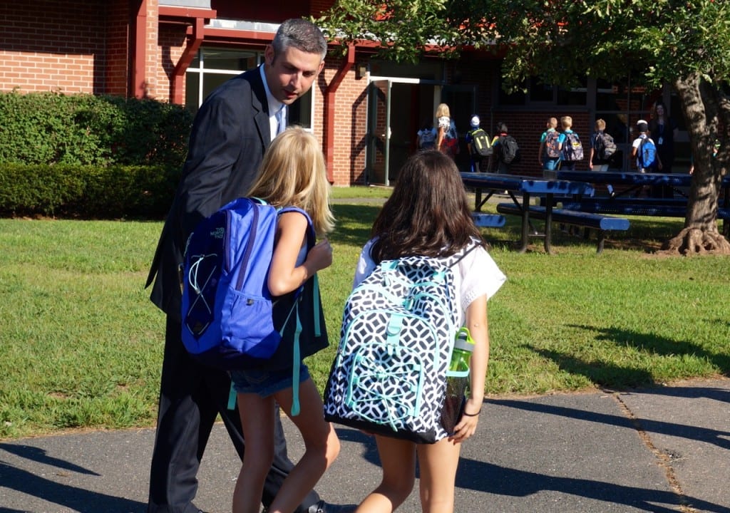 Braeburn Principal Jeffrey Sousa chats with some students as they head into the school to begin the first day. Photo credit: Ronni Newton