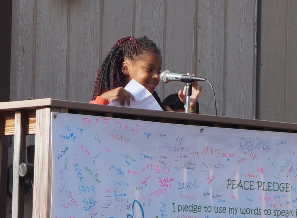 A Charter Oak student reads an inspirational quote on "International Day of Peace." Photo credit: Ronni Newton