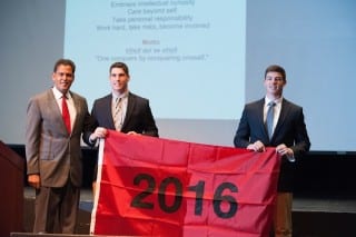 KO seniors Andrew and Austin Lemkuil receive the class flag from Head of School Dennis Bisgaard. Submitted photo