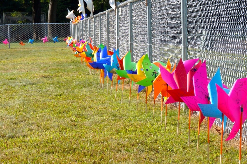Pinwheels for Peace spin in the breeze along the perimeter of the Charter Oak International Academy fence. Photo credit: Ronni Newton