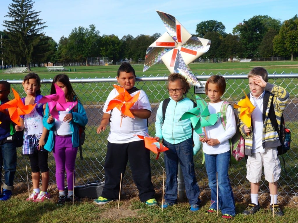 Students pose for a photo with their class before planting their pinwheels for peace. Photo credit: Ronni Newton