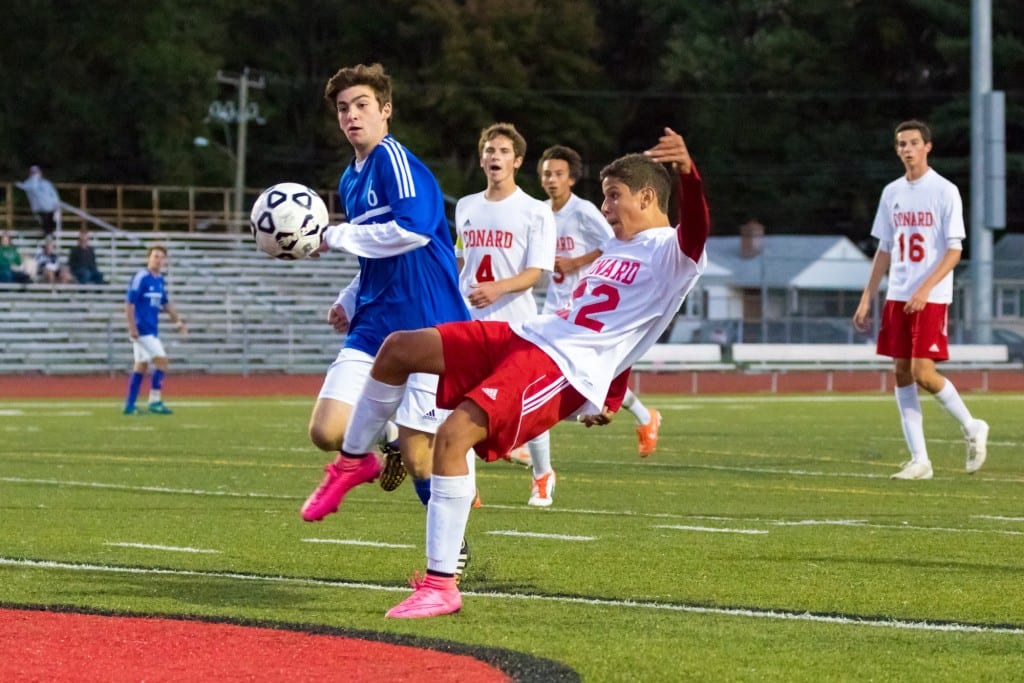Conard's Mario Santos (right) battles Hall's Pablo Miras-DeSimone for control of the ball. In background are (from left) Conard's Sam Newton, Kevin Presing, and Brendan D'Arcy. Photo courtesy of David Newman. PhotobyNewman.com