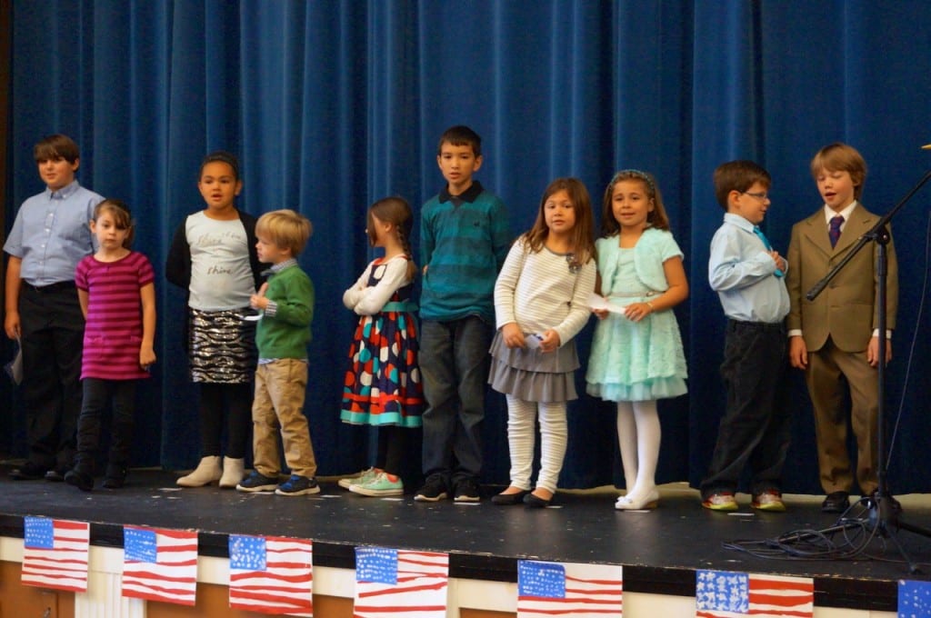 Charter Oak International Academy students read personal tributes to veterans. Veterans Day 2015. Photo credit: Ronni Newton