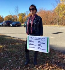 Maria Verrengia holds up a sign representing the Democratic slate at Wolcott Elementary School on Election Day. Photo credit: Ronni Newton