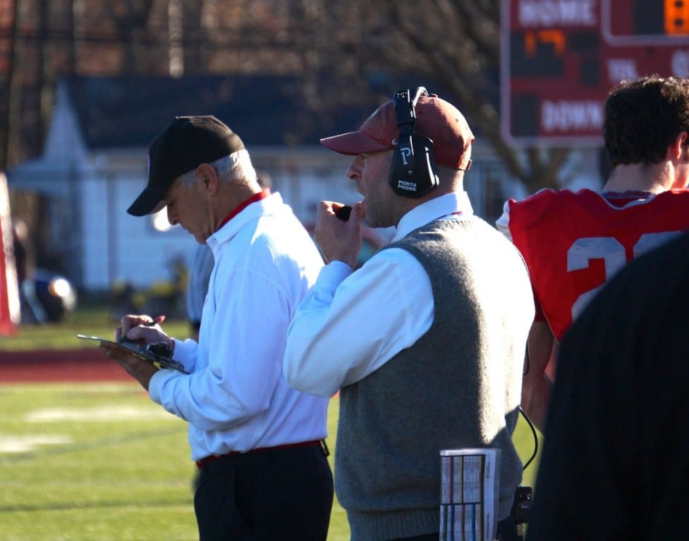 Conard Head Coach Matt Cersosimo (in vest) is assisted on the field by his father, former Conard head coach Rob Cersosimo. Annual Conard vs. Hall West Hartford Mayor's Cup football game. Nov. 21, 2015. Photo credit: Ronni Newton
