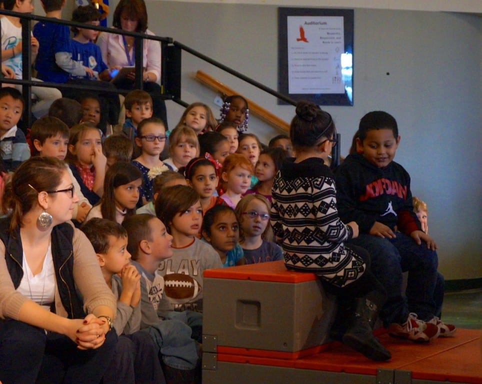 Students look on while first graders demonstrate the use of the Buddy Bench. Photo credit: Ronni Newton