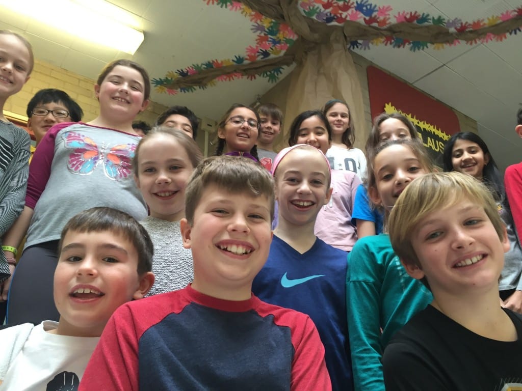 Bugbee Elementary School students stand in front of the international tree of peace, with colorful leaves representing each child’s cultural roots. Submitted photo