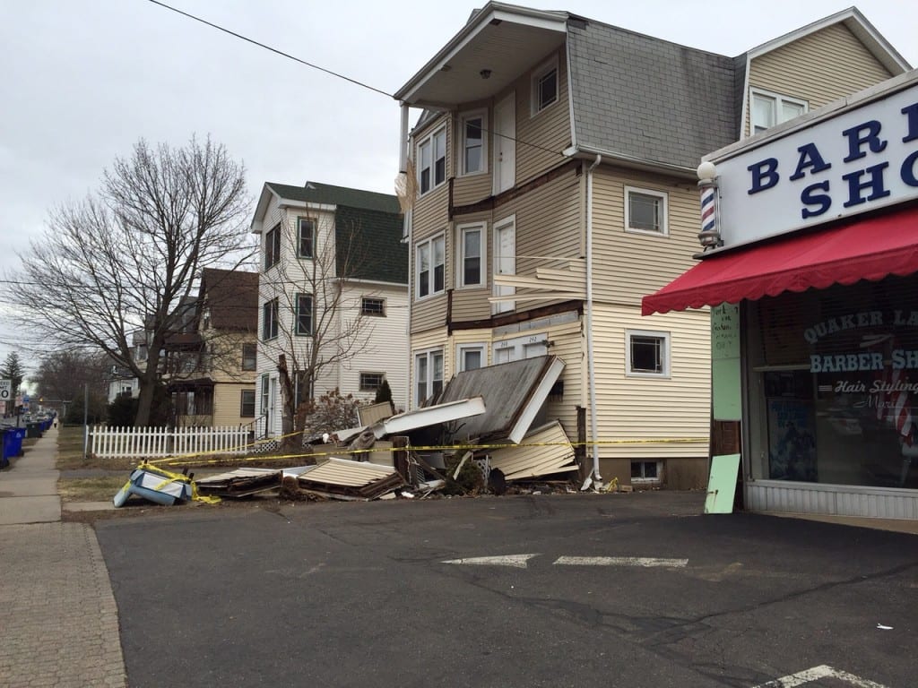 According to the property manager for 240-242 South Quaker Ln., a vehicle clipped the corner of the barber shop's building before hitting the support that held up the porches for the multi-family residence. Photo credit: Ronni Newton