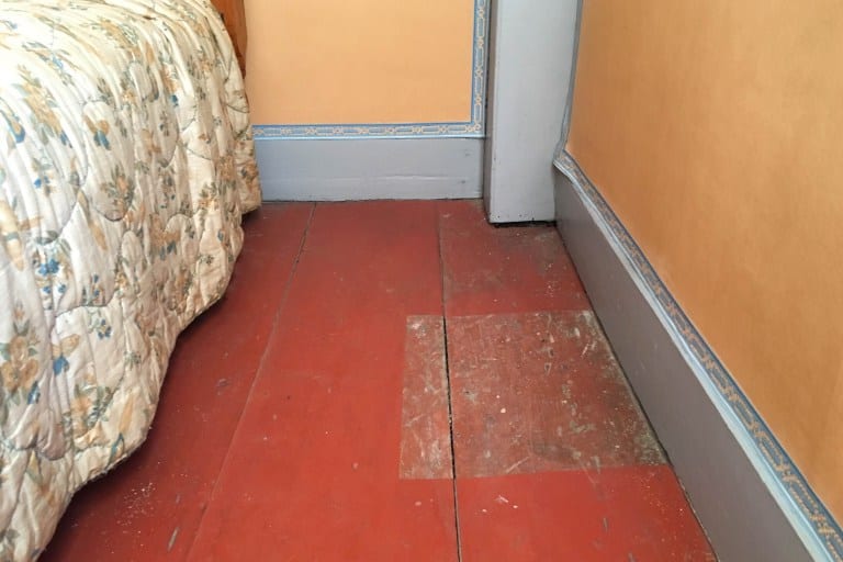 The current red floor color was applied after professional paint analysis revealed the original paint color in the square on the right. The shade looks different due to chemical changes over time. Photo credit: Deb Cohen