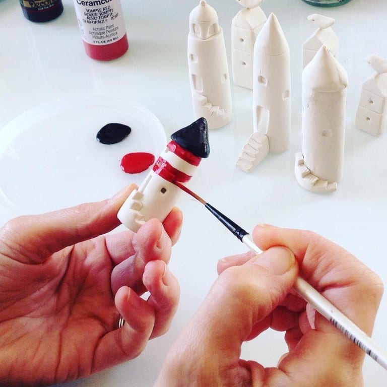 Julie Phillipps paints a clay lighthouse. Submitted photo