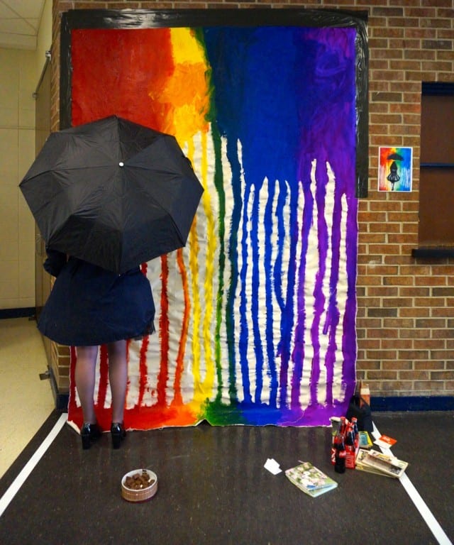 Natalie Wright posing as the girl with the umbrella in the painting on the wall to her right. Photo credit: Ronni Newton