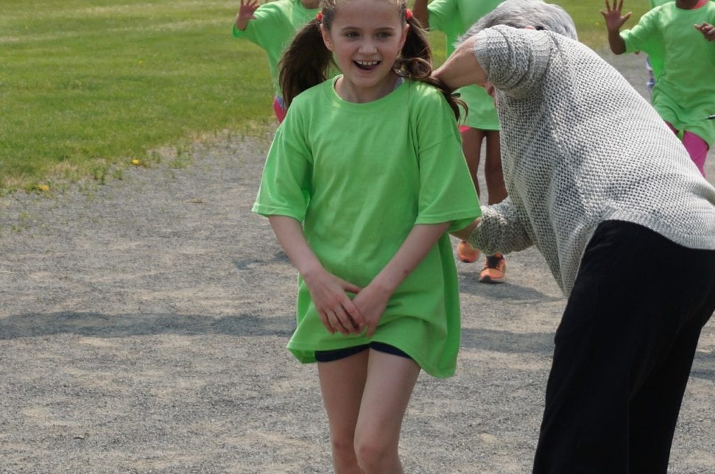 A student gets a check mark on the back of her t-shirt for completing a lap, courtesy of Town Council member Beth Kerrigan. Whiting Lane Rock 'n Run. May 20, 2016. Photo credit: Ronni Newton