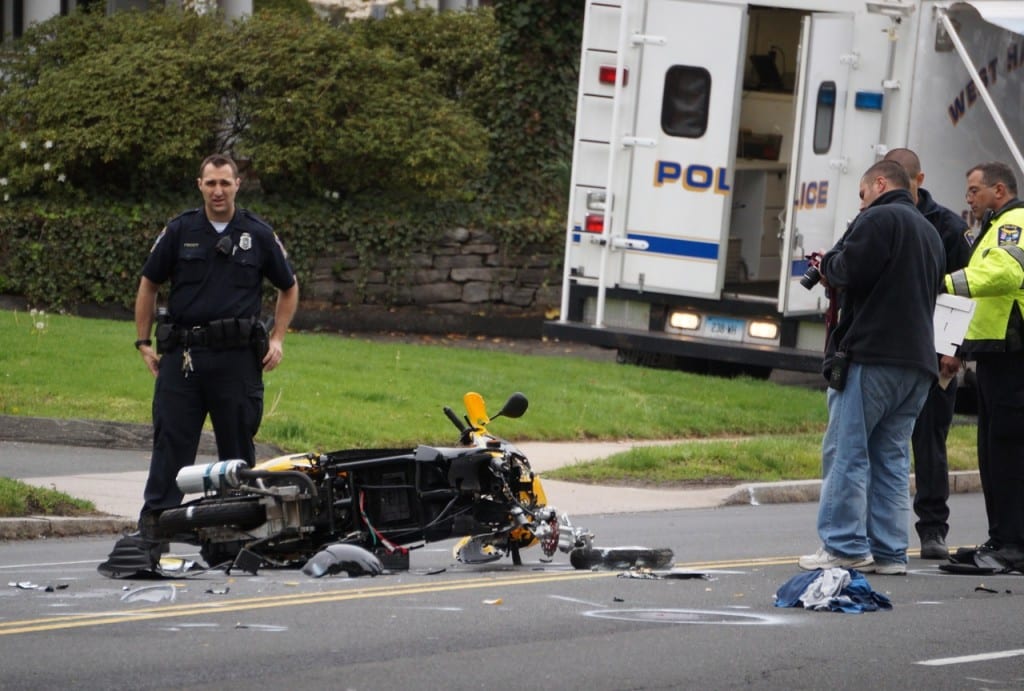 West Hartford Police investigate the scene of a crash between a scooter and an SUV on South Main Street. Photo credit: Ronni Newton