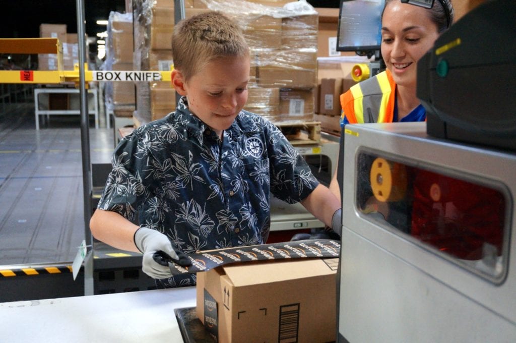 Britt Housum seals up a box he packed at the Amazon Fulfillment Center. Photo credit: Ronni Newton