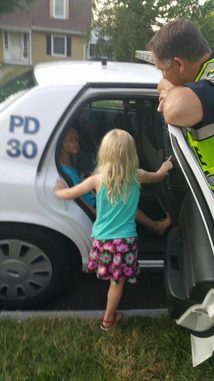 Cassandra Cockburn's daughter gets to check out a police car. Courtesy of Cassandra Cockburn