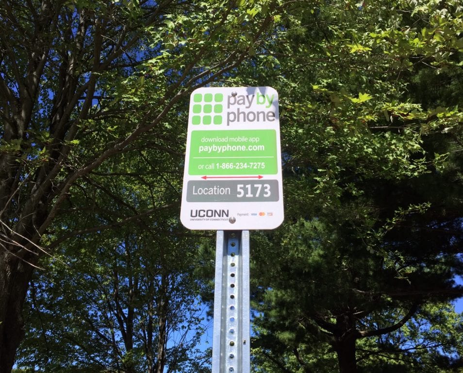 Certain spaces in the UConn parking lot on Trout Brook Drive are marked with 'pay by phone' signs. Photo credit: Ronni Newton