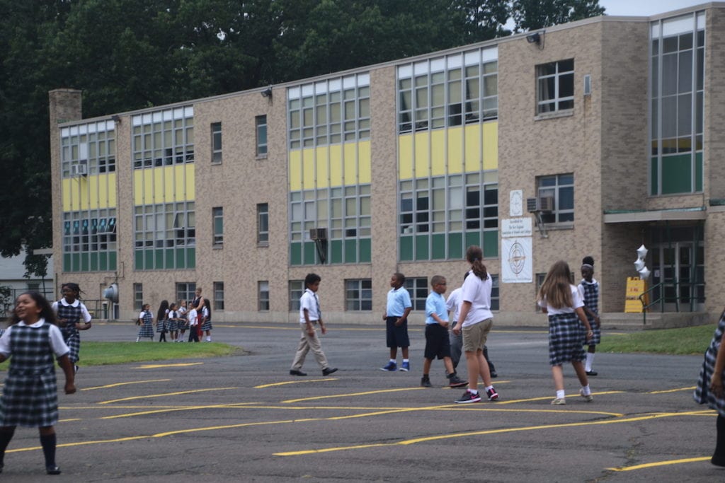 Students at the beginning of the school year at St. Brigid-St.Augustine: The Partnership School. In the center surrounded by the students is seventh-grade teacher Melissa Seidl. Photo credit: Dylan Carneiro