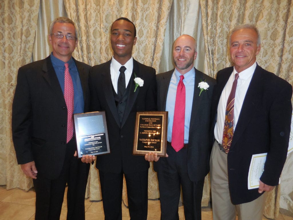 Nate Richam with assistant coach Steve Garneau (far left), head coach Matt Cersosimo and former head coach Rob Cersosimo at the National Football Foundation Northern Connecticut Chapter's Awards Banquet in May. Submitted photo