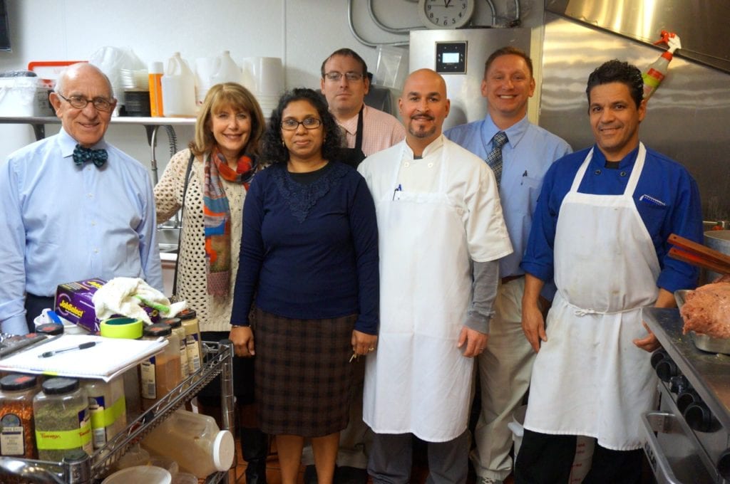 Crown Market & Cafe investors and management (from left): Henry Zachs, Ann Pava, Office Manager Mona Dhanraj, Deli Manager and Mashgioch Michael Klein, Matty Arsenault, Store Manager Michael Hanson, and Hector Echeandia. Photo credit: Ronni Newton