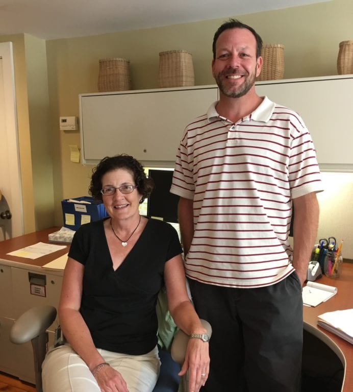Lynn Lipscombe (seated) now has a job she loves with Jim Whitney's (standing) company – a great match made by the  Seniors Job Bank. Photo credit: Sheila Diamond