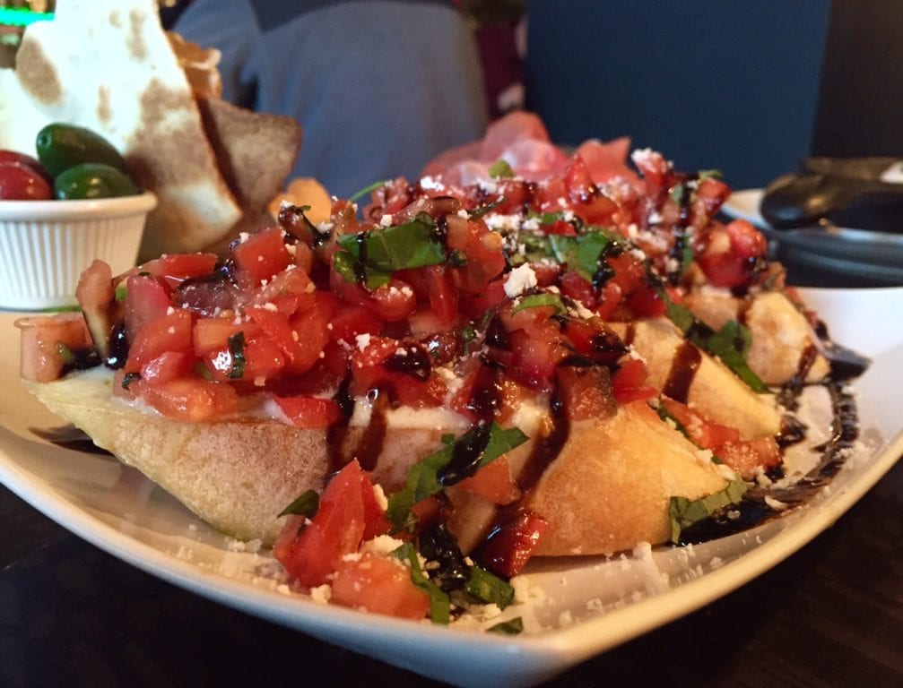 Bruschetta with gorgonzola cheese, fresh plum tomatoes, basil and EVOO is a happy hour favorite. Photo credit: Ronni Newton