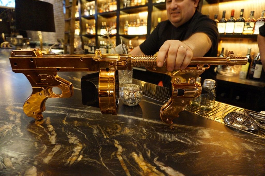 Chef Alex Petard shows off a copper gun used to 'shoot' champagne at Noble & Co. Photo credit: Ronni Newton
