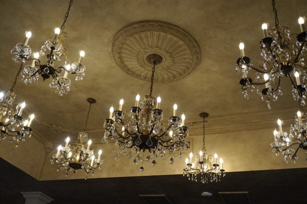 A collection of antique chandeliers light the center of the Noble & Co. dining area. Photo credit: Ronni Newton