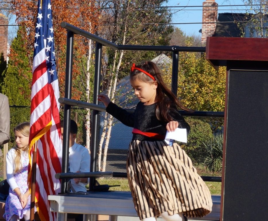 A student skips off stage after making her personal remarks about bravery. Veterans Day 2016. Photo credit: Ronni Newton