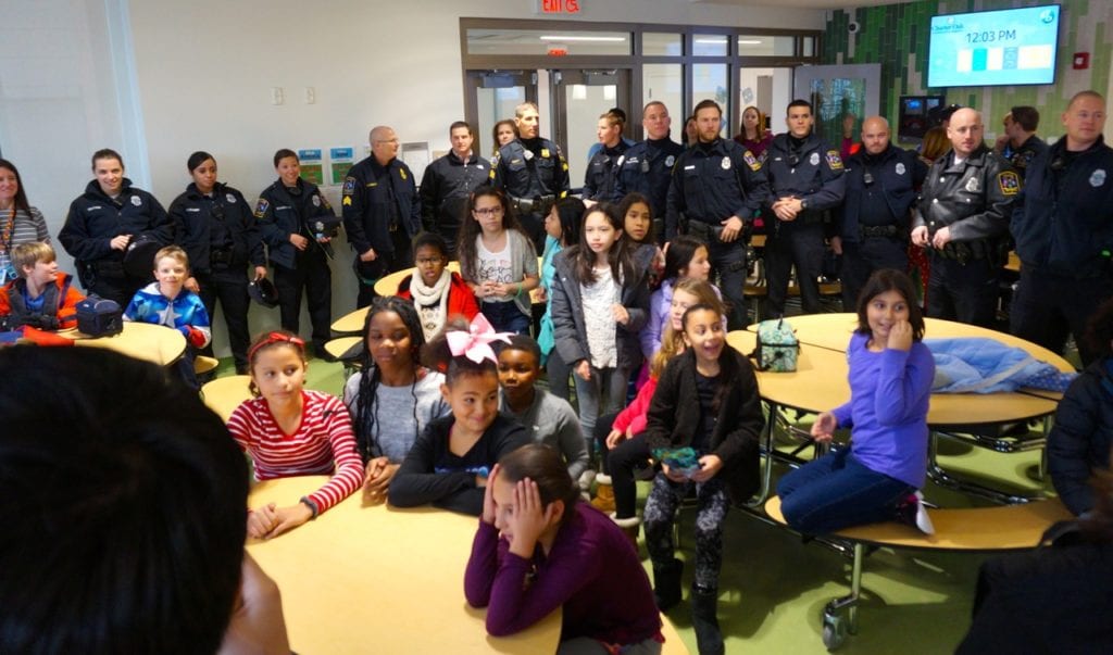 At least 20 members of the West Hartford Police fill the Charter Oak International Academy cafeteria to express their gratitude to Faith Brown. Photo credit: Ronni Newton