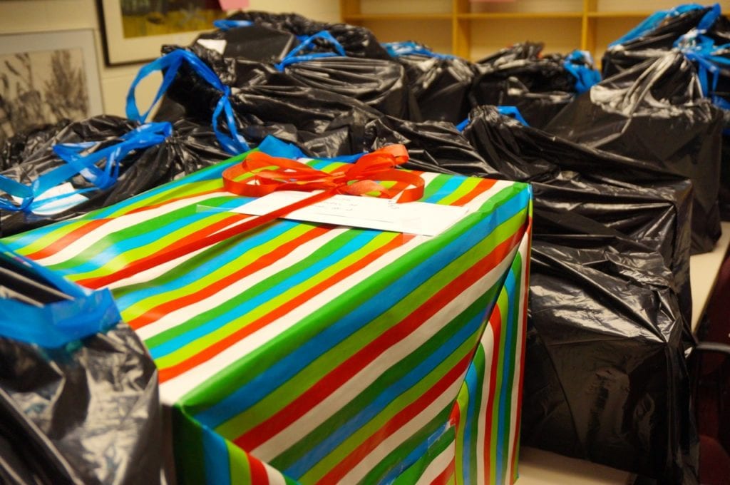 Conard Holiday Helpers fill a conference room with bags and boxes of toys and other holiday gifts for needy students in the community. Photo credit: Ronni Newton