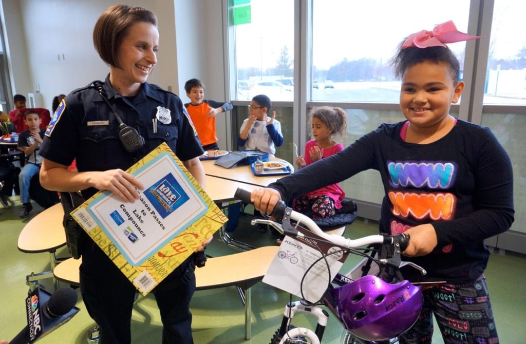Faith Brown (right) is excited to receive a brand new bike and helmet. West Hartford Police Off. Irene Leonard (right) holds a certificate for two season passes to Lake Compounce. Photo credit: Ronni Newton