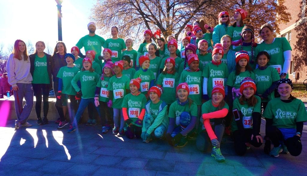 Some of the 50-plus members of Girls in Stride pose for a photo with their coaches. HMF Blue Back Mitten Run, West Hartford, Dec. 4, 2016. Photo credit: Ronni Newton