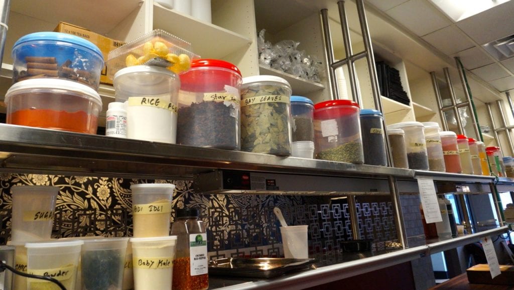 Spices line the kitchen at INDIA Restaurant & Bar. Photo credit: Ronni Newton