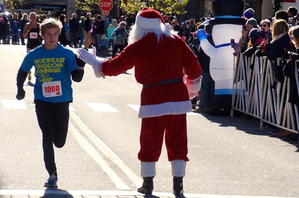Jake Rocheleau of West Hartford high-fives Santa on the way to his 15th place finish. HMF Blue Back Mitten Run, West Hartford, Dec. 4, 2016. Photo credit: Ronni Newton