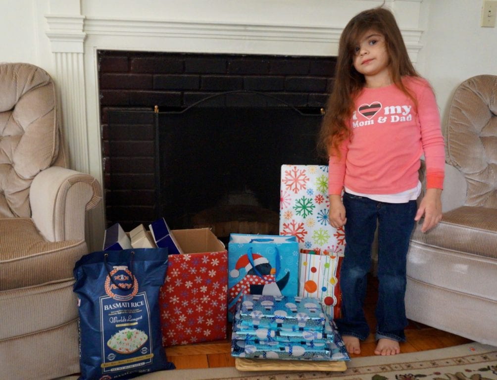 Jana Kattoub stands next to the donated gifts in the family's West Hartford apartment. Photo credit: Ronni Newton