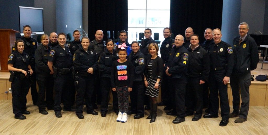 Faith Brown poses with Mayor Shari Cantor and members of the West Hartford Police Department in the auditorium of the new Charter Oak International Academy building. Photo credit: Ronni Newton